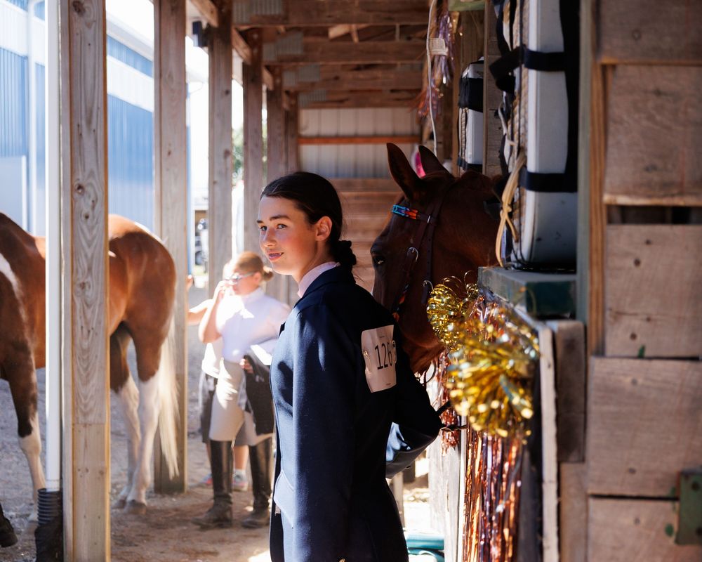 Interior view of a weathered wooden barn structure with sunlight streaming through gaps, creating a rustic ambiance.