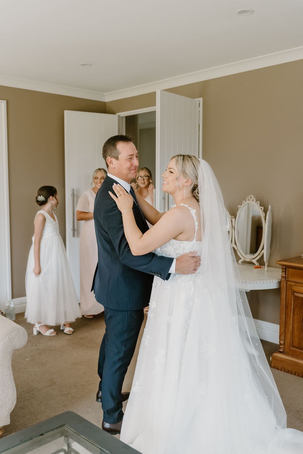 A tender moment between newlyweds as they share their first look in an elegantly decorated room.