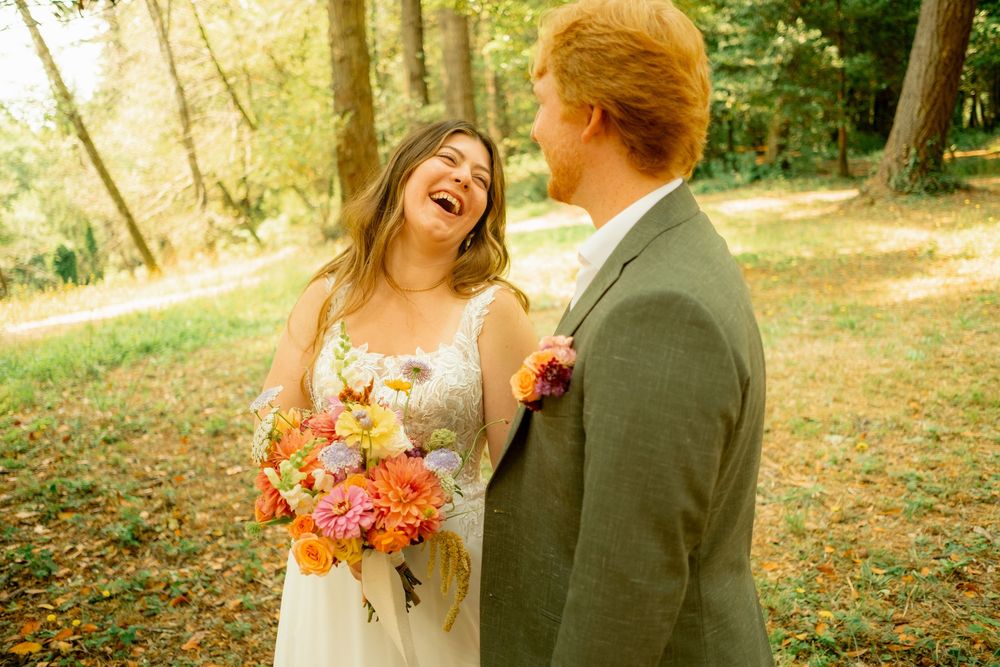 Couple sharing joyful moments during an outdoor autumn wedding photoshoot.