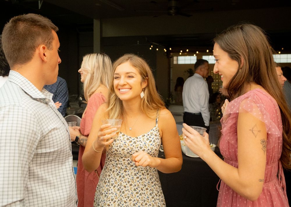 Wedding guests smile and dance together during a lively reception celebration.