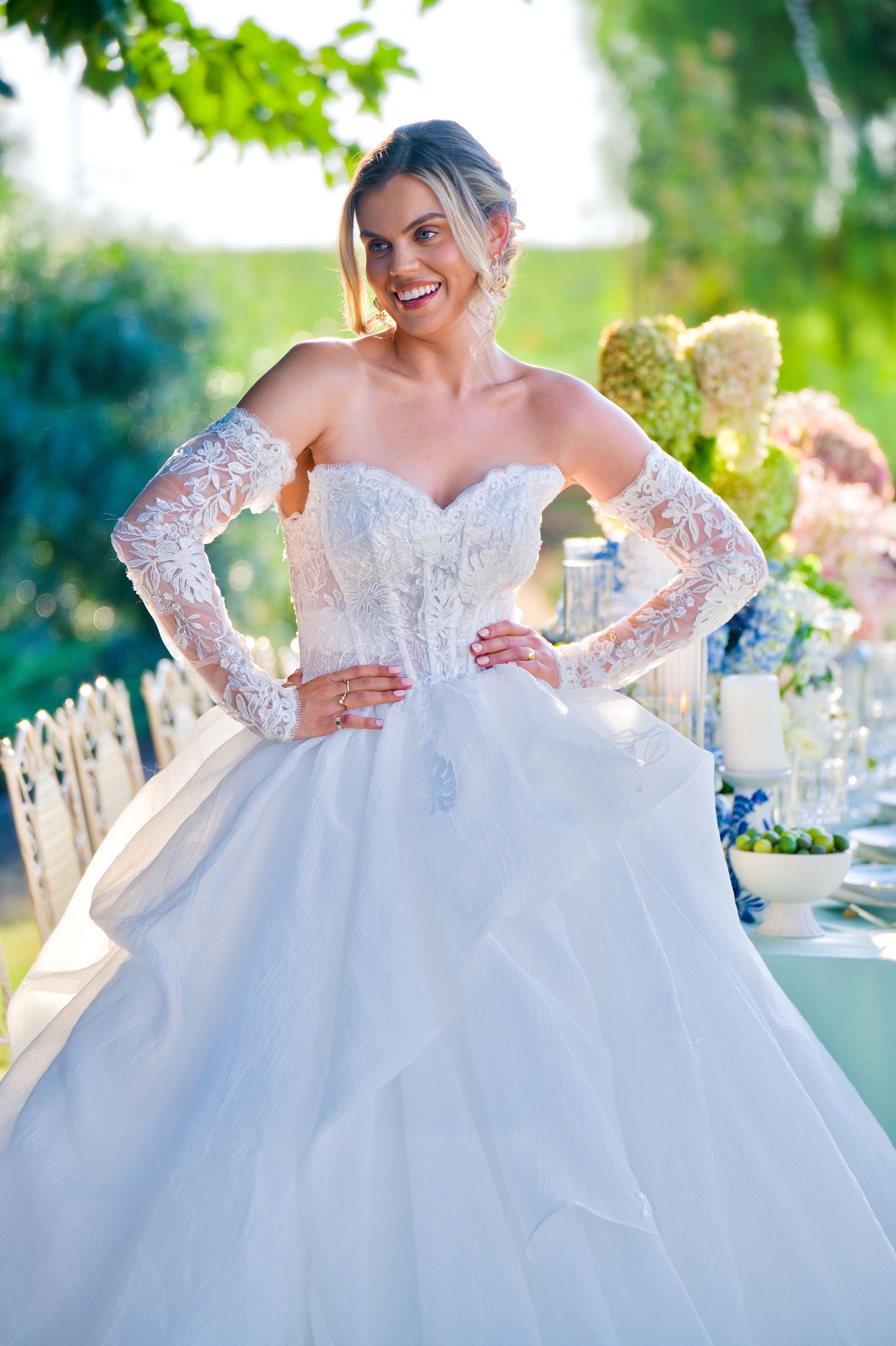 Ornate white ball gown wedding dress with delicate lace long sleeves and full tulle skirt.