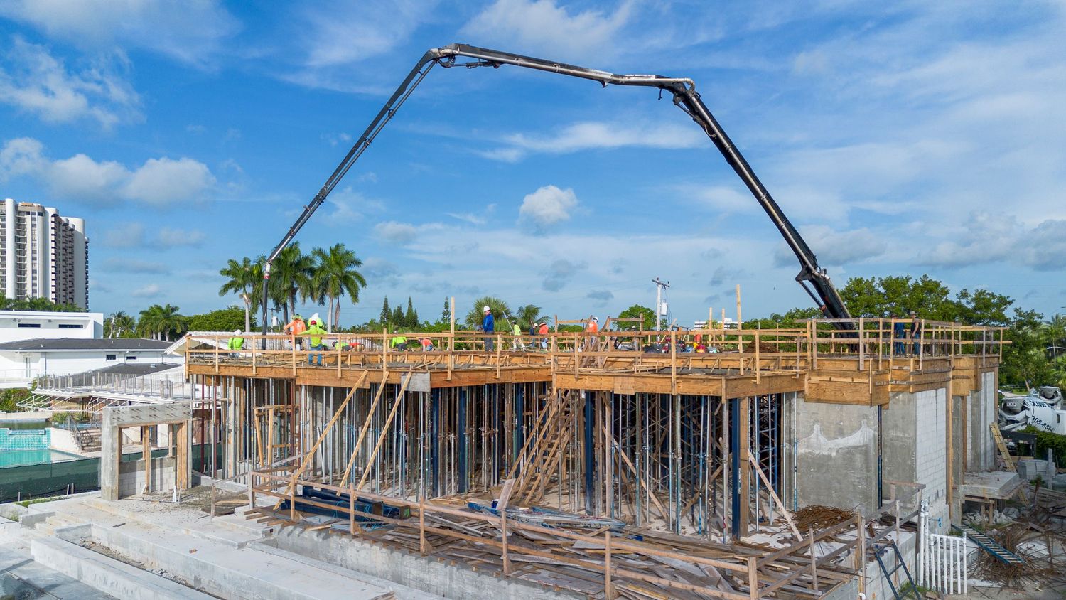 Construction site with large crane equipment against blue sky working on waterfront development.