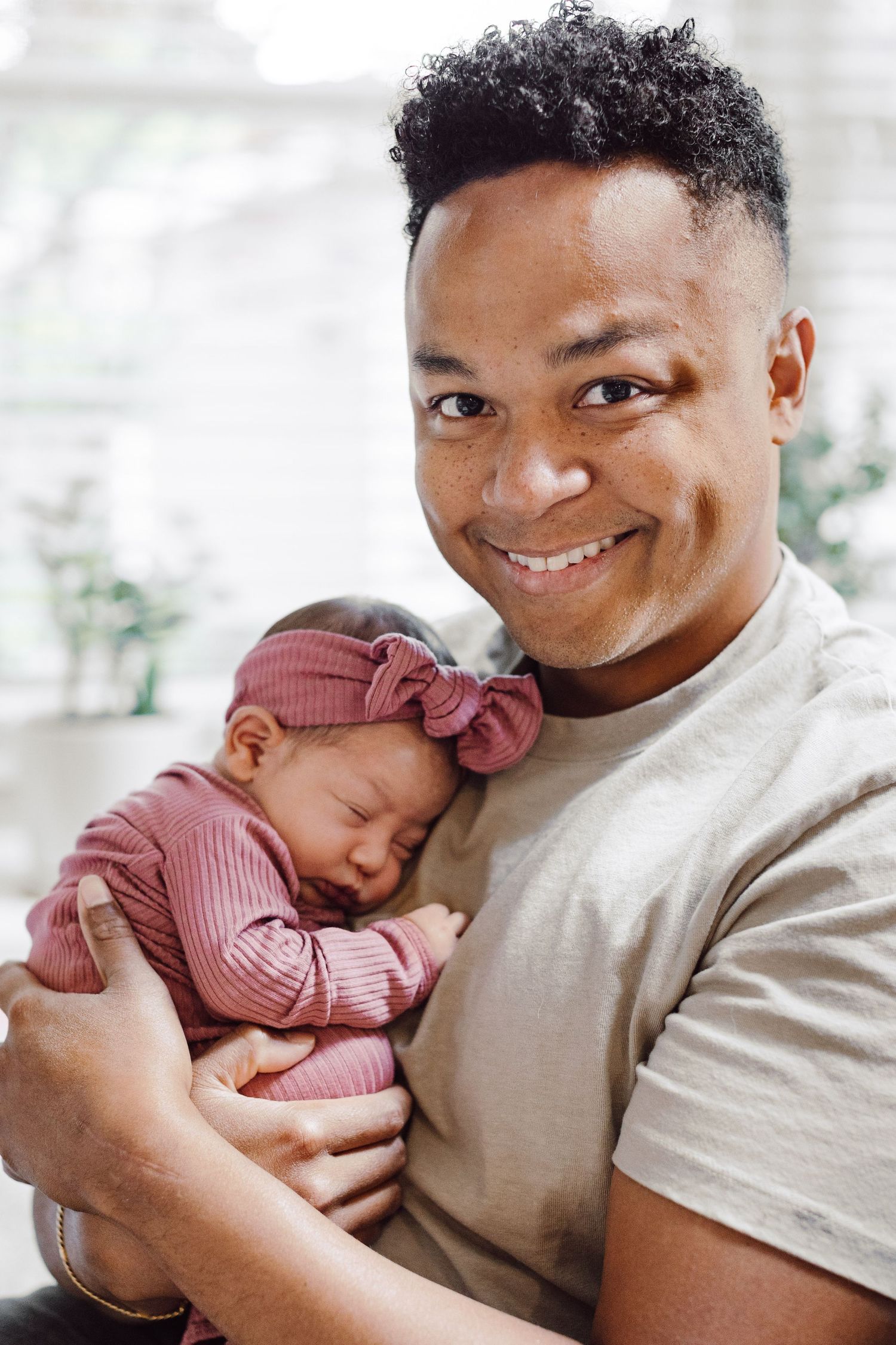 Sweet moments captured between parent and newborn baby in natural light.