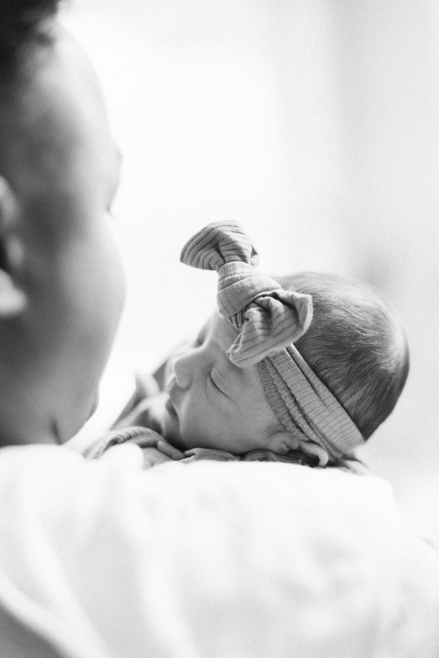 Black and white portrait of sleeping newborn baby in soft lighting.