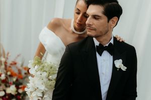 Romantic wedding couple embraces in front of floral decor at elegant indoor ceremony.
Cabo wedding photographer