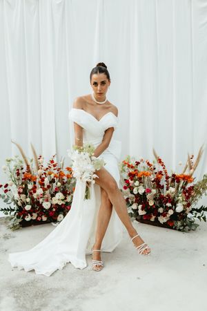 Modern bridal portrait series with white gown against draped backdrop and red and white floral arrangements.
Tulum wedding photographer