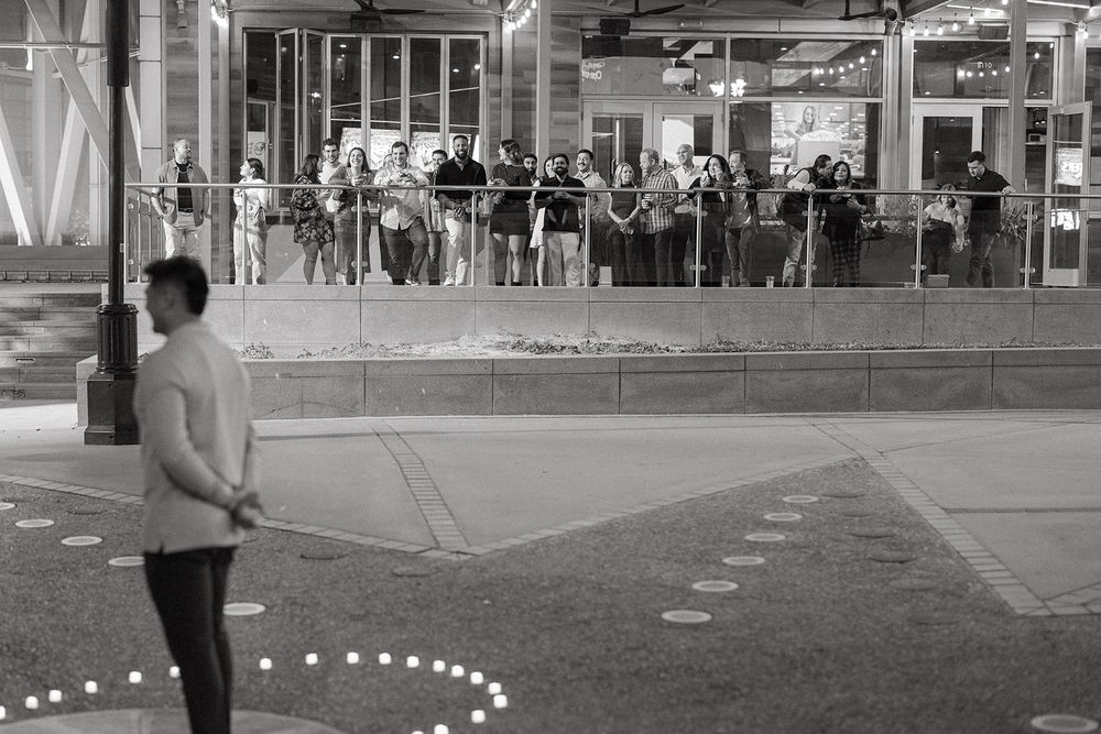 Black and white photo of people standing in front of a large building with dotted lines overlaid on the ground.