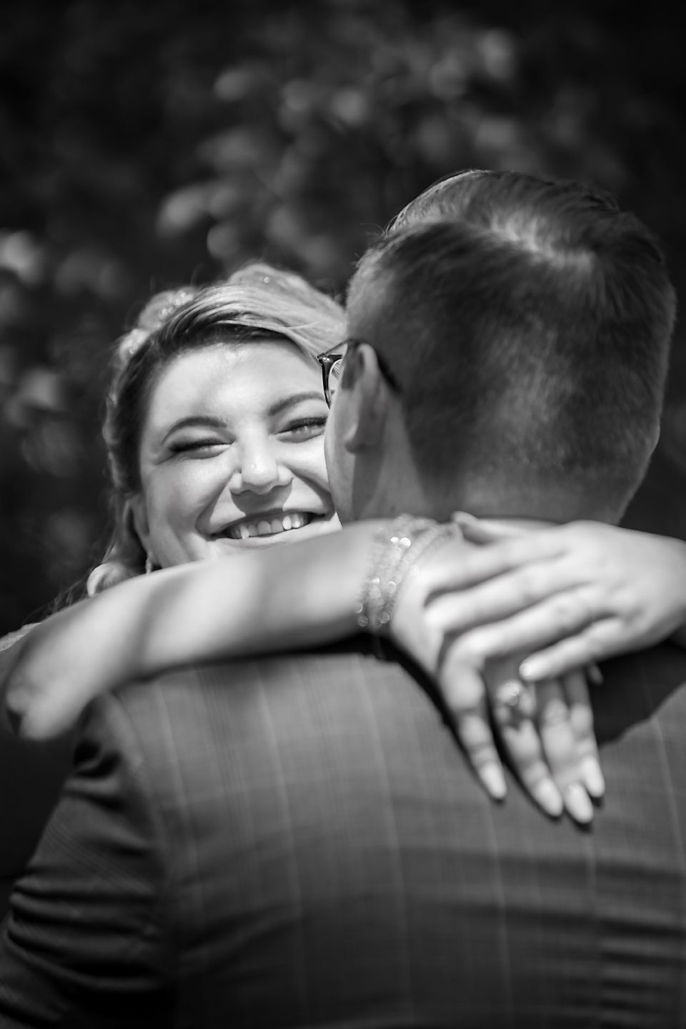 Four black and white photos showing a couple embracing emotionally while holding hands in a romantic moment.