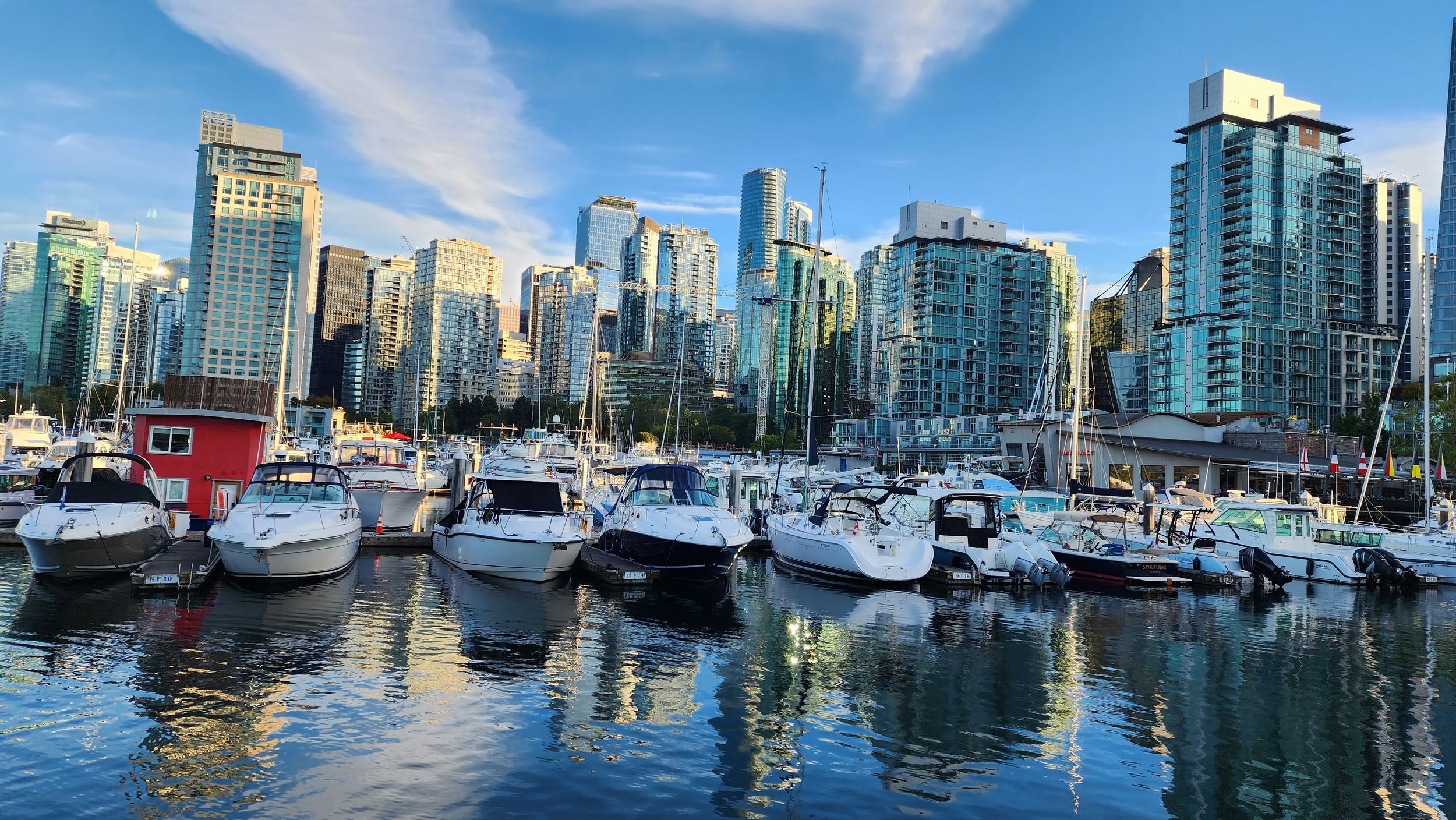 Downtown Vancouver skyline with boats at the marina on a sunny day.