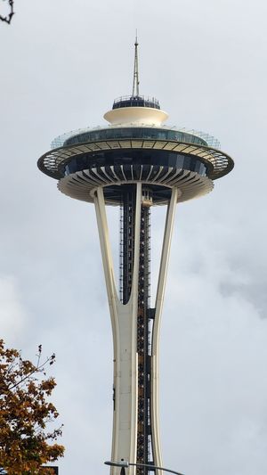 Space Needle structure with a circular observation deck against a pale sky.