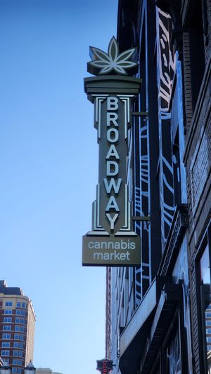 Broadway Street sign with cannabis shop in downtown Seattle.