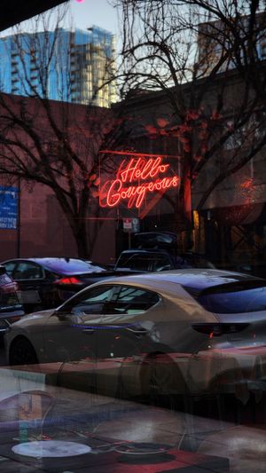 Neon Hello Gorgeous sign reflection in the store front glass.
