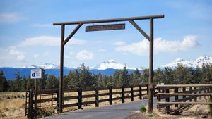 Wooden arch entrance to a rural Oregon farm with blue skies.