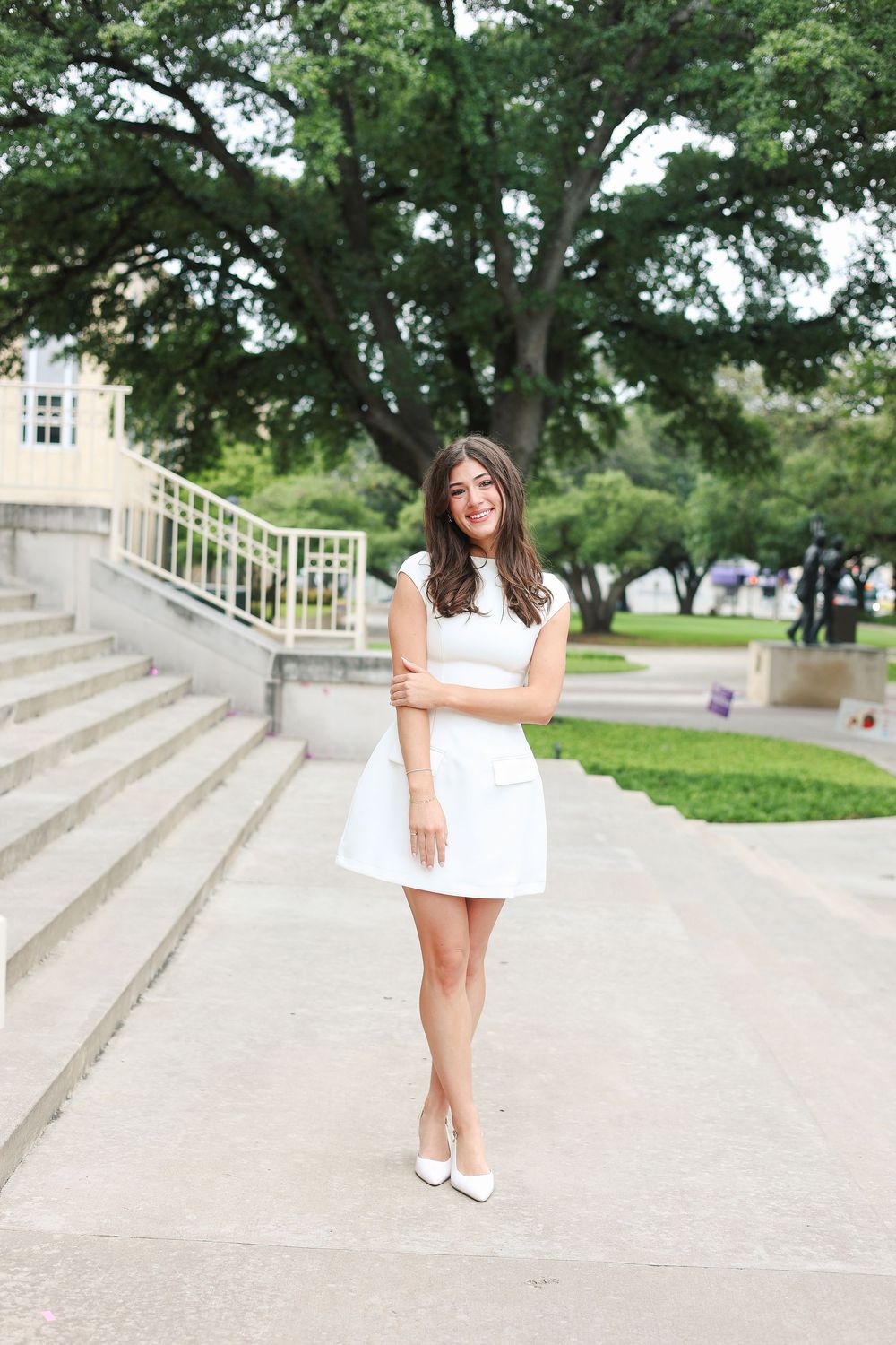 Stone steps and green trees create a classic backdrop for outdoor graduation photos.