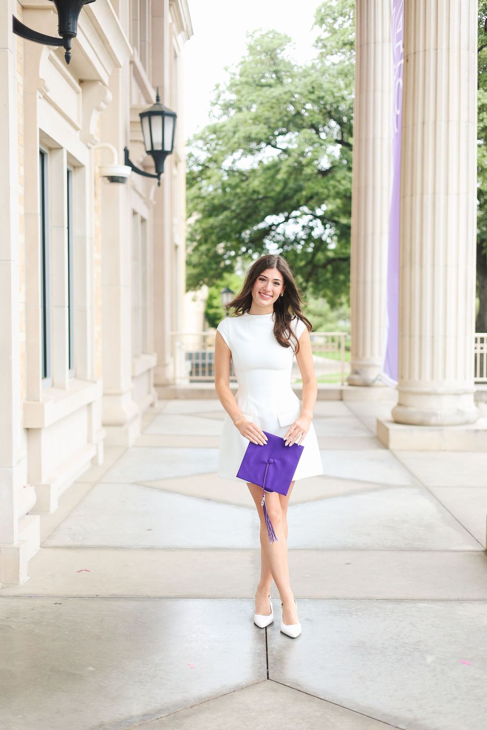 White columns frame an elegant walkway for graduation portraits with purple accents.