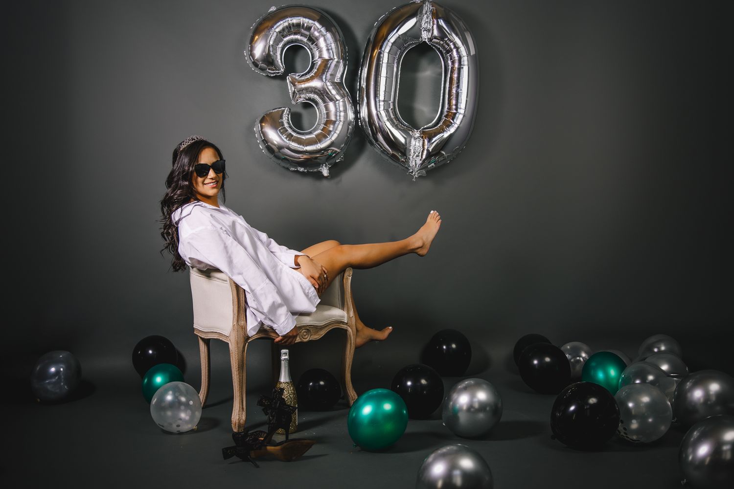 Studio birthday photoshoot of a women posing on a chair while she celebrates her 30th birthday in a Greeley Colorado studio.