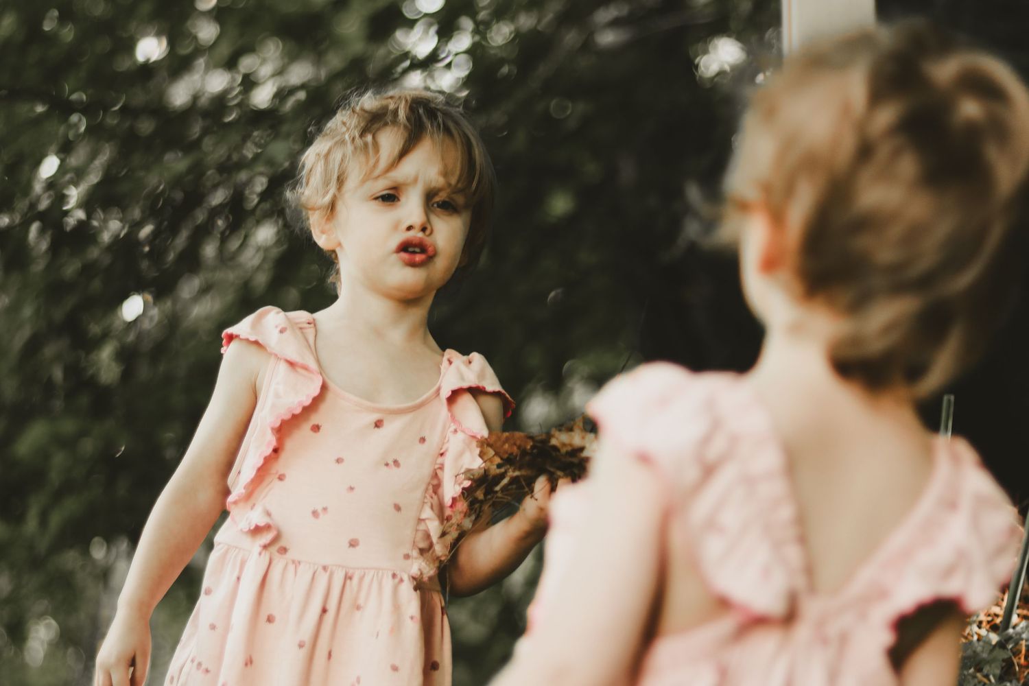Vintage-style photography of a pink dress with delicate details in natural lighting.