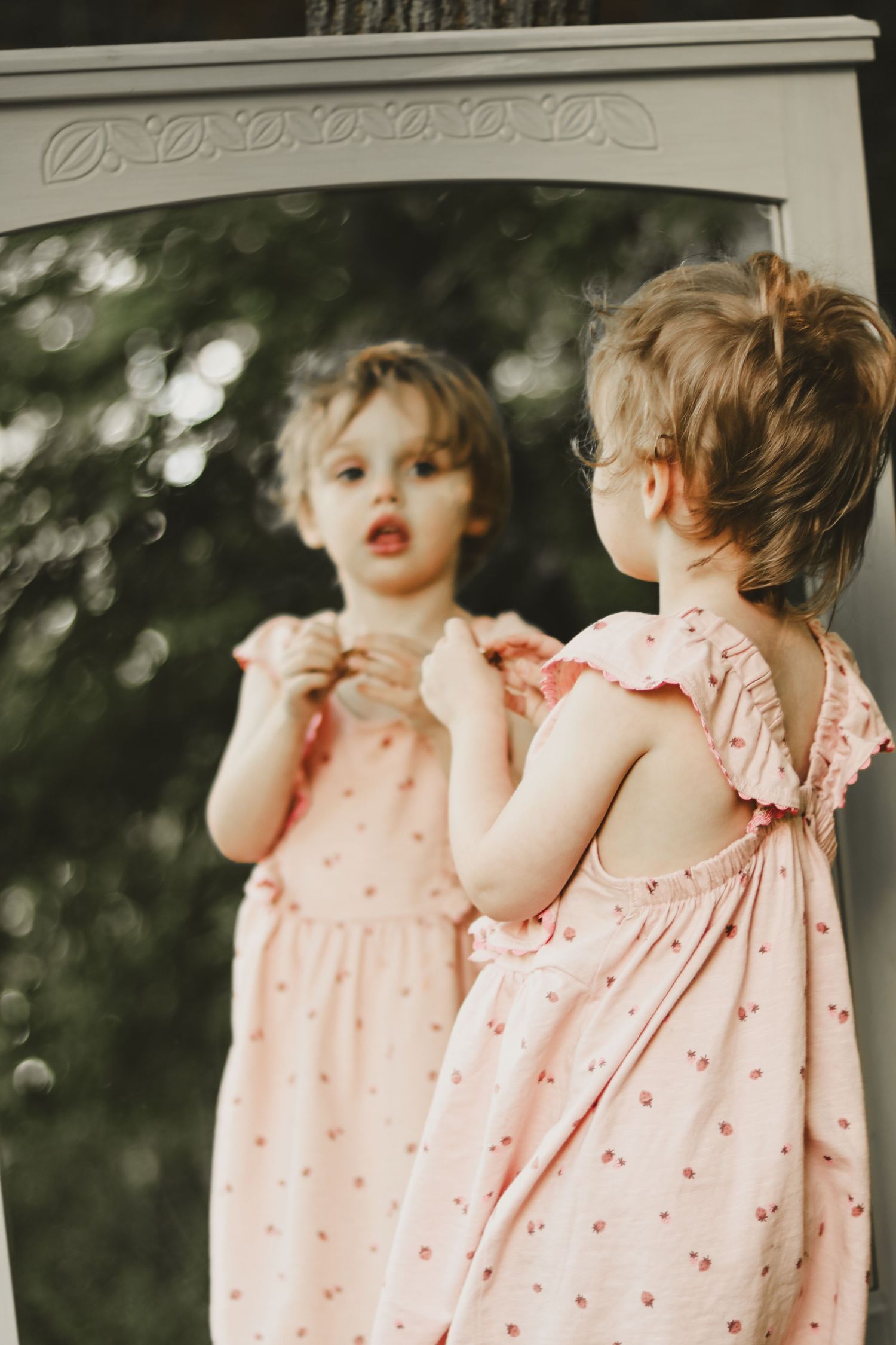 White porch scene with a flowing pink dress captured in natural afternoon light.