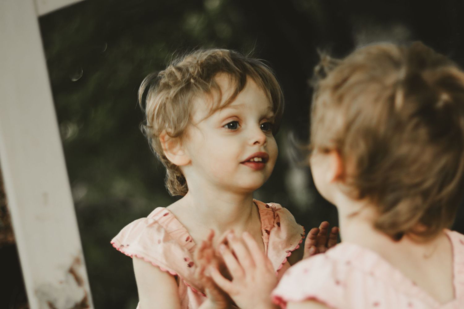 Artistic portrait featuring a pink polka dot dress in a garden setting.
