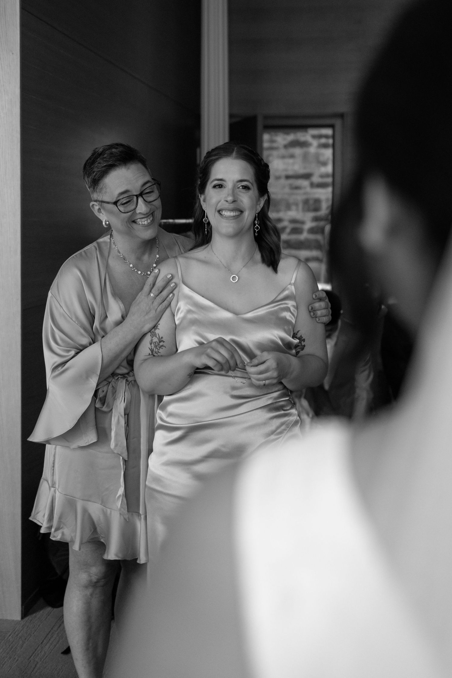 A candid black and white moment showing two wedding guests emotional together captured by Montreal wedding photographer, Aliza Dworkind.