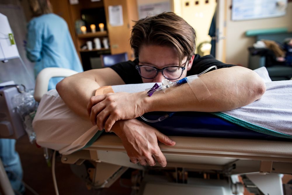 Healthcare provider attending to patient on hospital bed with medical equipment.