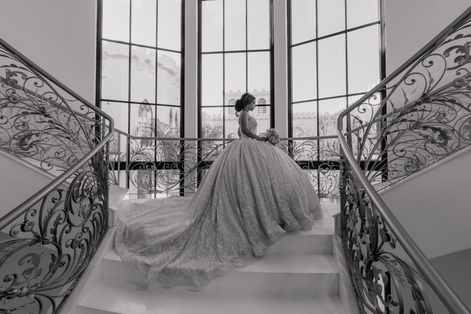A black and white photo montage of ornate staircase railings and architectural details in an elegant interior setting.