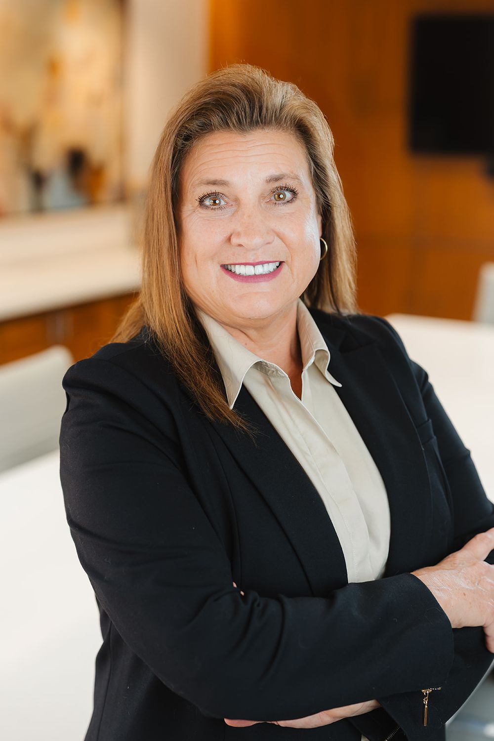 Professional headshots of person in business attire smiling against a light interior background.