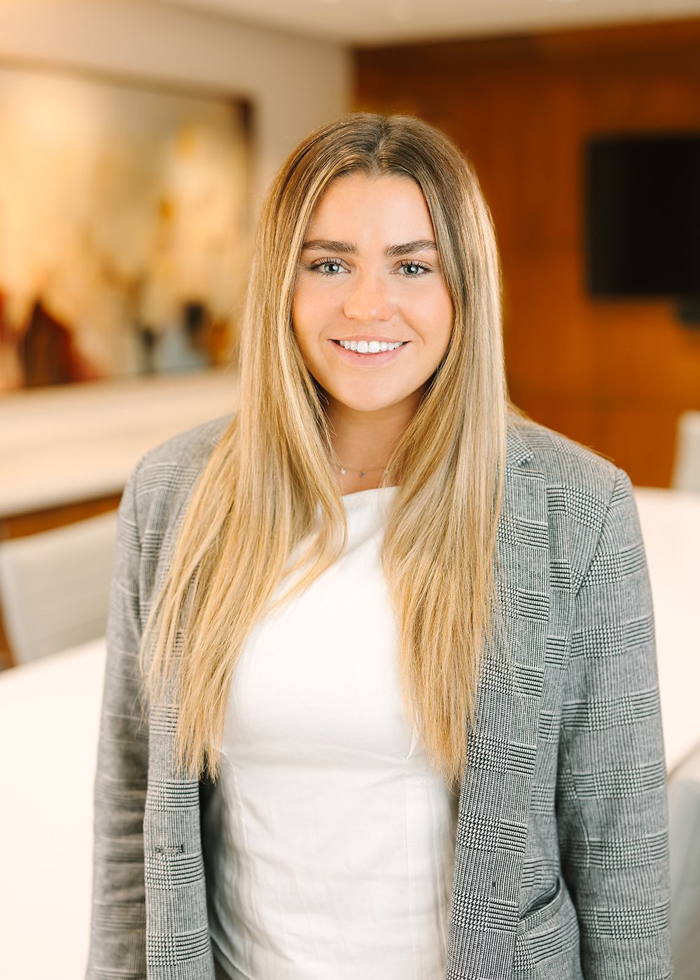 Professional woman in gray blazer and white top shown in a series of expressive headshots in an office setting.