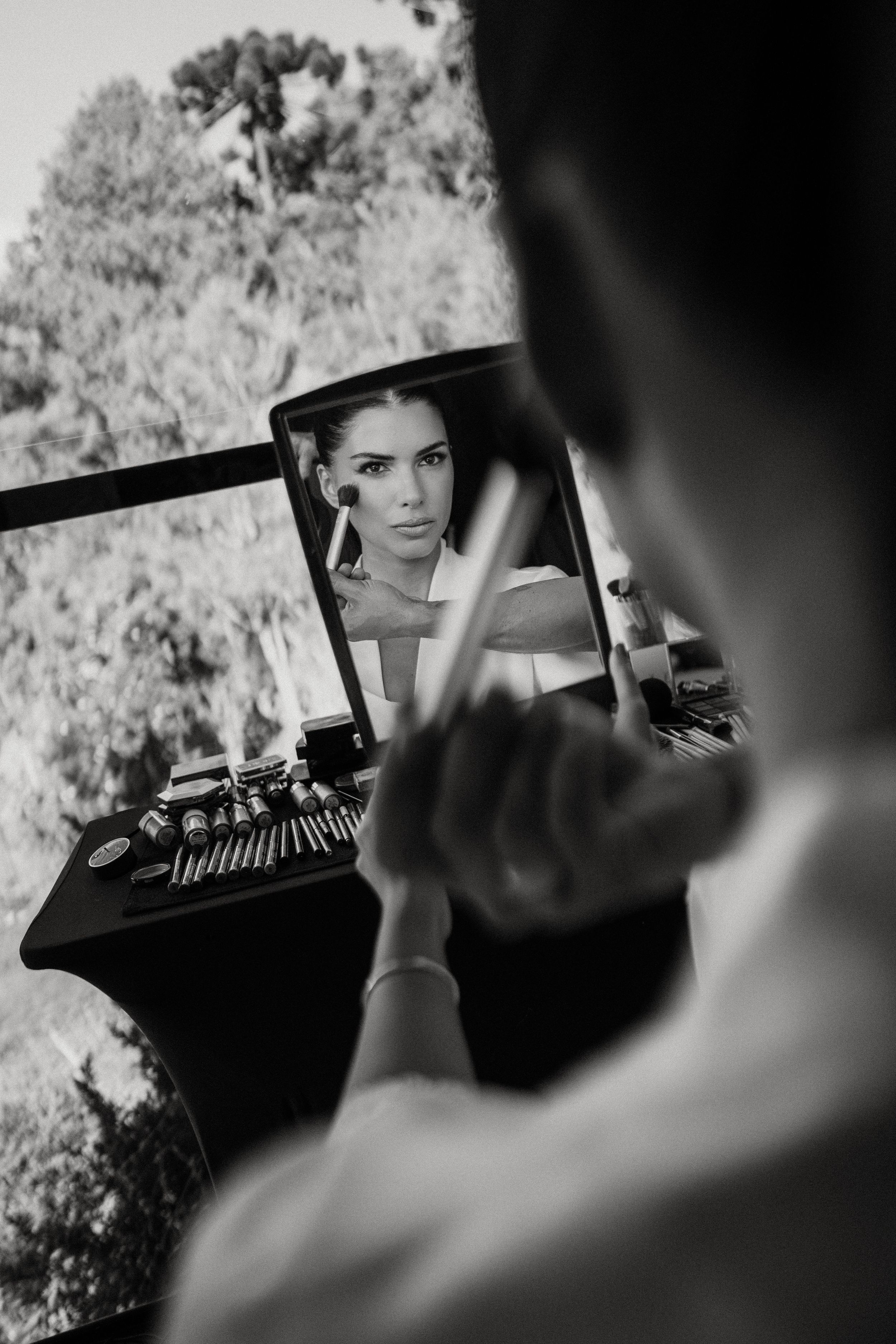 A black and white artistic photo showing a reflection in an antique typewriter against a blurred outdoor background.