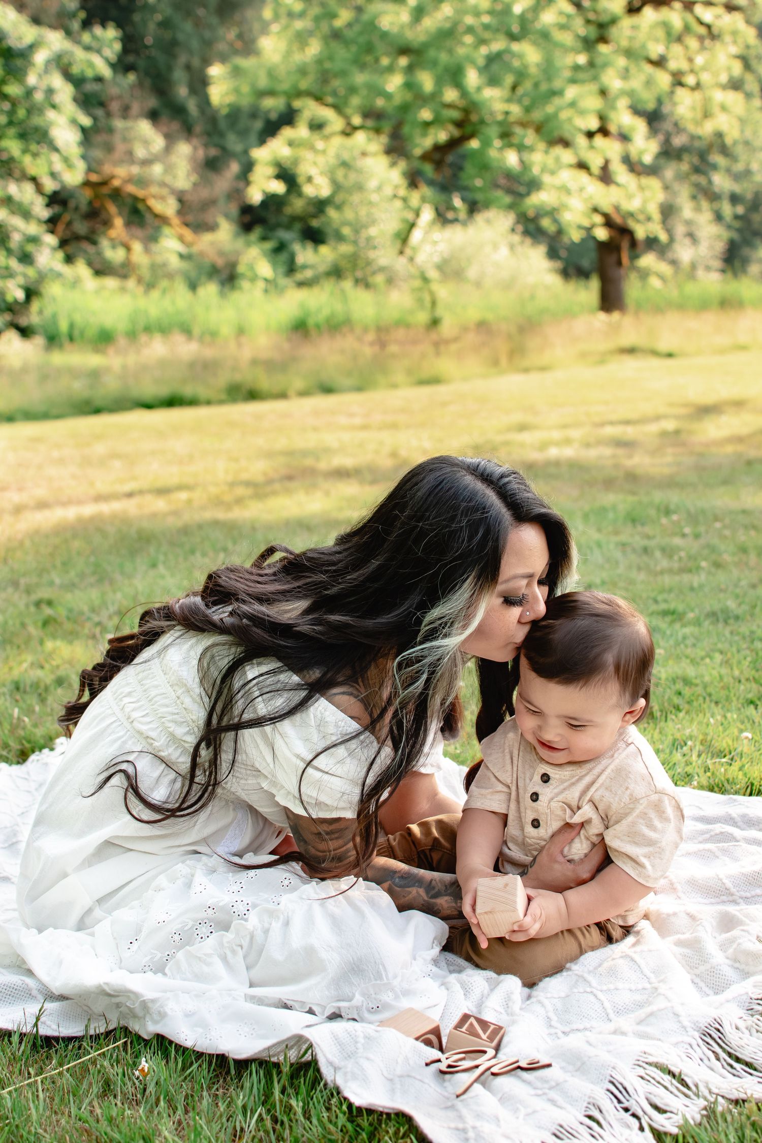 Mother cuddling baby during natural light motherhood session in Washington field