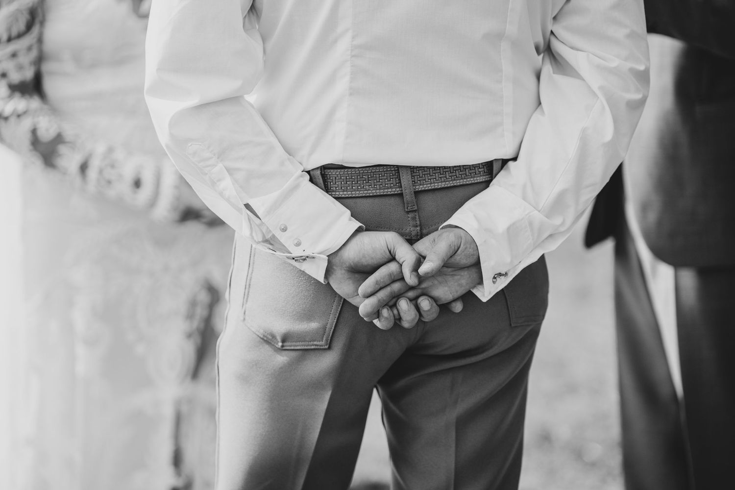 Wedding party walking together outdoors in formal attire while holding hands.