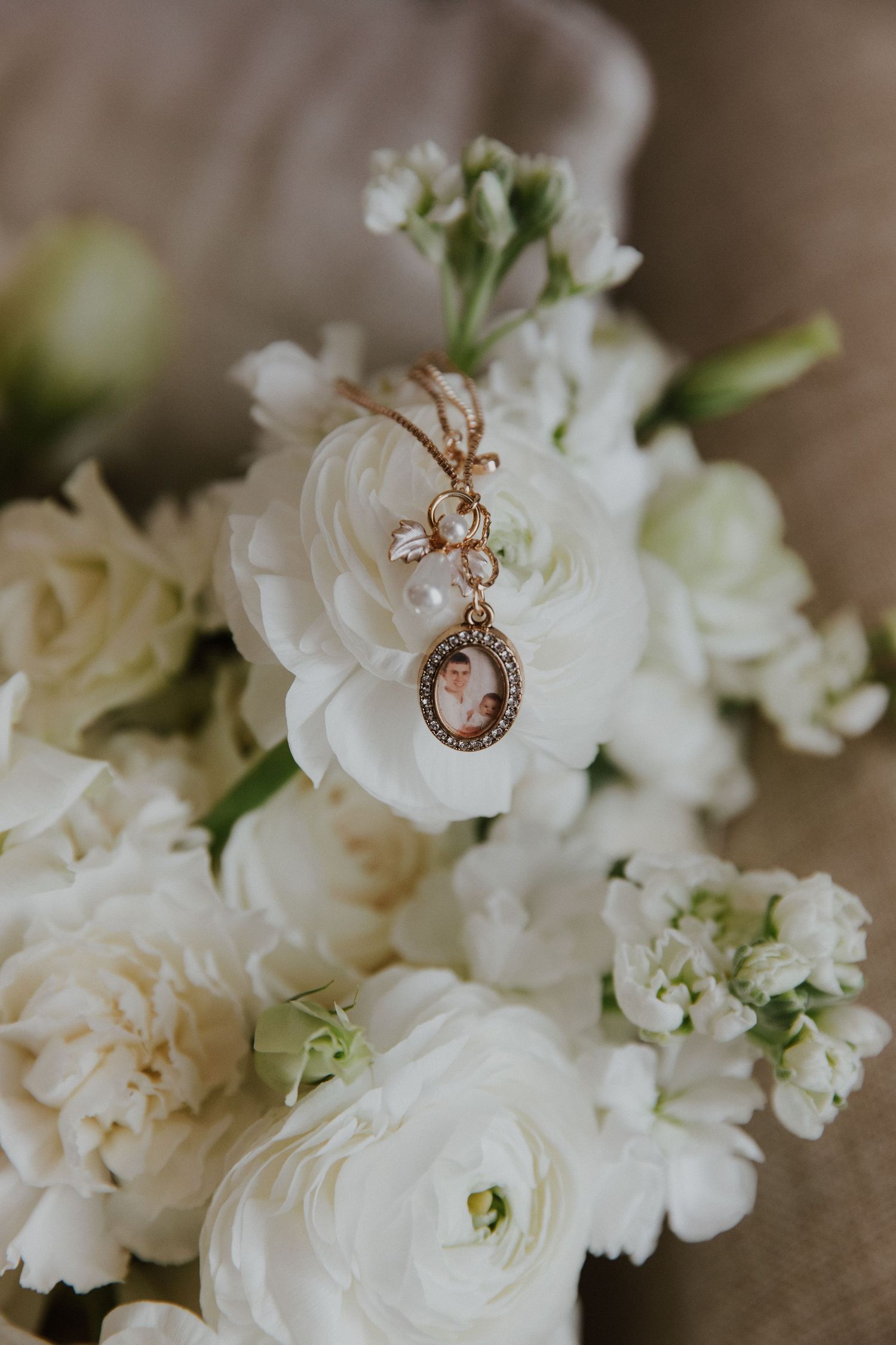 Vintage-style rose gold pendant necklace resting on white flowers with delicate petals.