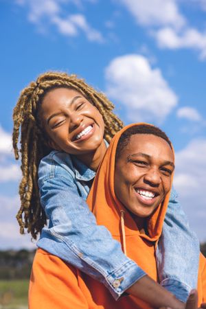 Joyful moment captured outdoors against blue sky on a sunny day.