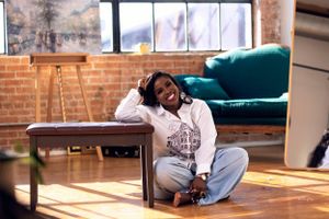 Artistic photoshoot in a sunlit industrial loft space with brick walls.