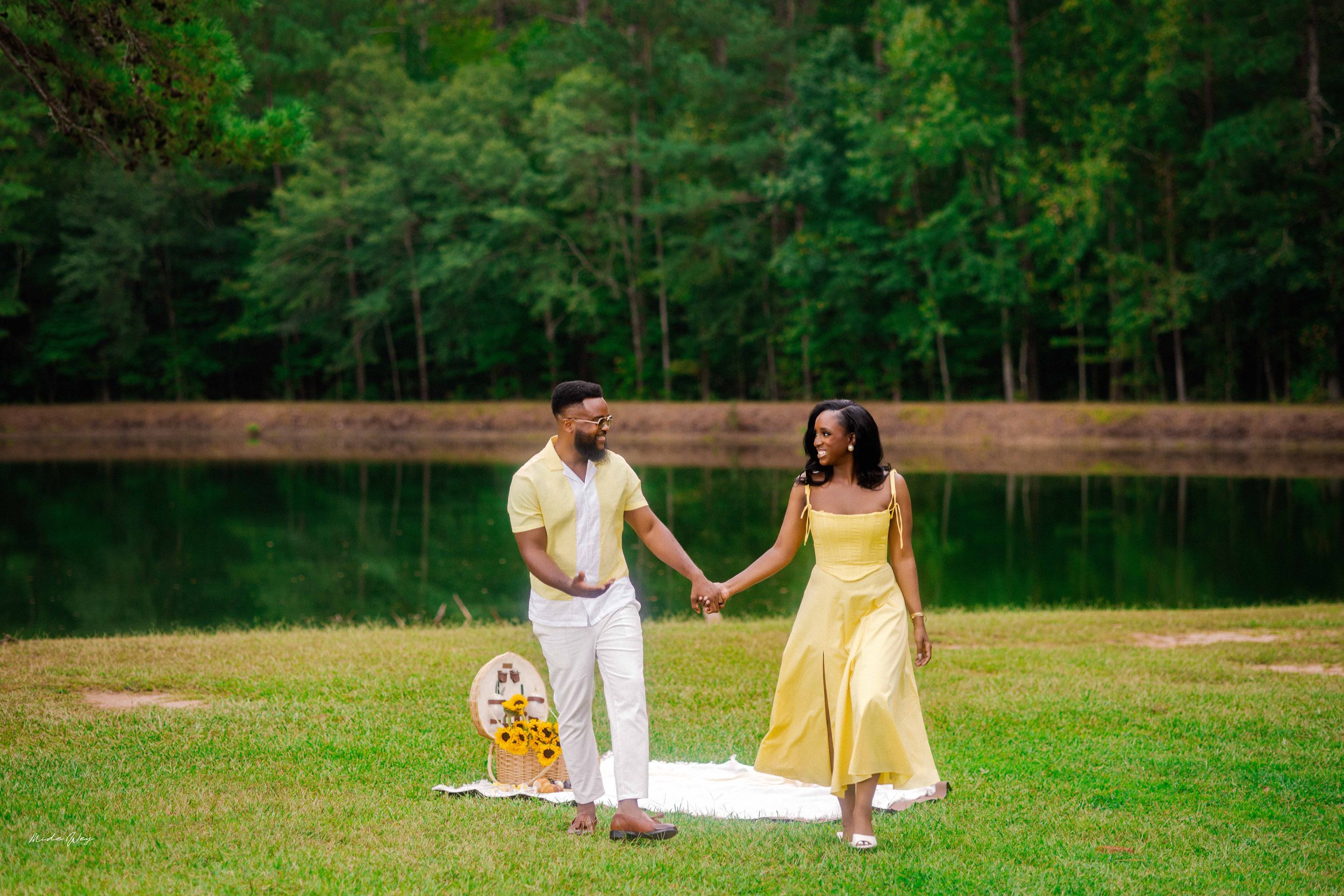 Playful engagement photos in a serene park setting with yellow sundress.