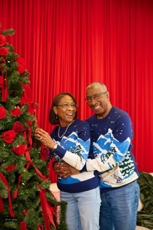 Holiday portrait session featuring matching winter sweaters and festive decorations.