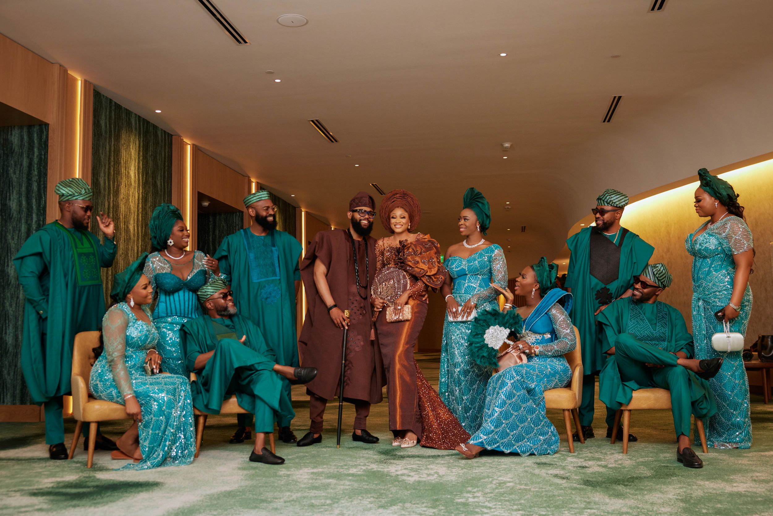 Group photo session featuring coordinated traditional outfits in teal and brown tones.