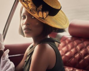 Stylish portrait featuring vintage hat and dramatic side profile pose.