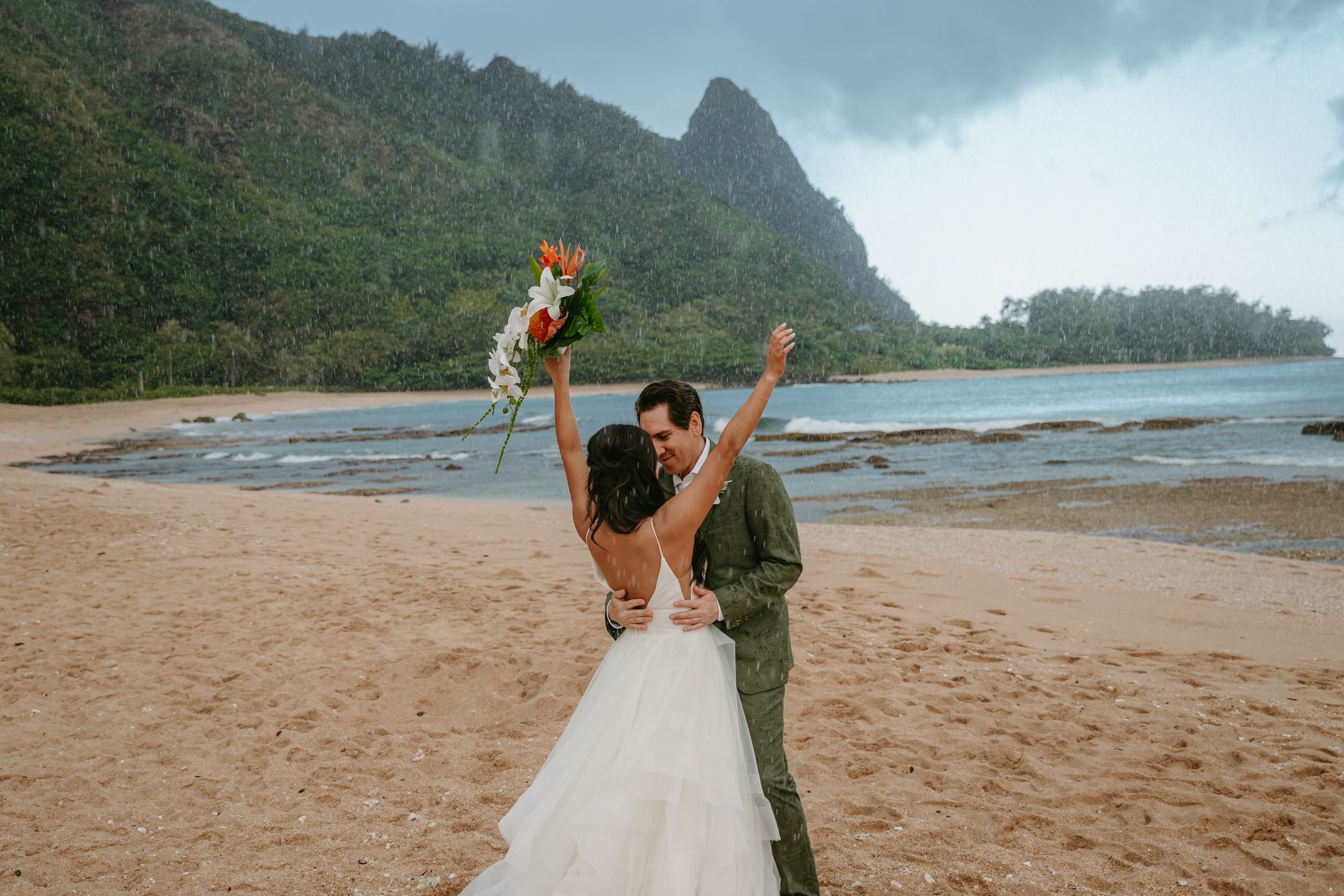 Romantic sunset photoshoot at a secluded beach with mountains and coastline in the background.