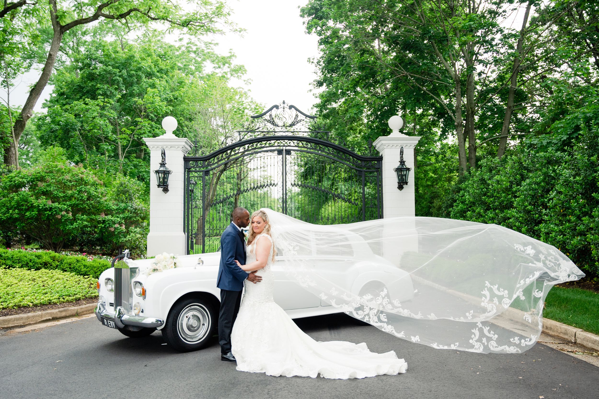 Wedding photography sequence outdoors with flowing veil and classic car in lush garden setting.