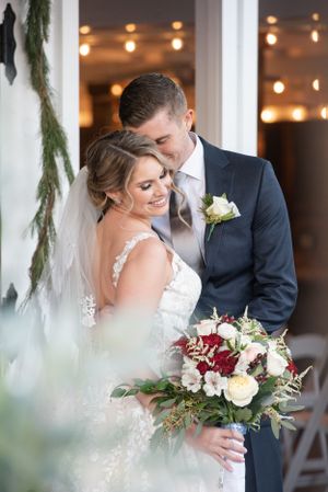 Romantic wedding portraits with winter greenery decorations and soft lighting.
