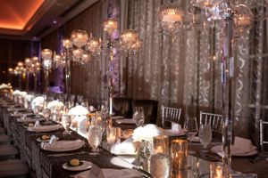 Elegant reception hall with crystal chandeliers and luxurious table settings.