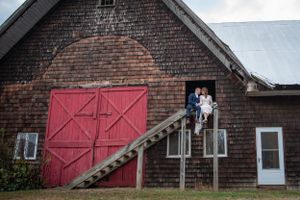 Rustic brick barn exterior with red wooden doors creates charming backdrop.