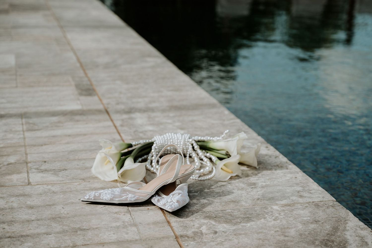 Artistic photo of bridal pieces next to a pool at Yeppoon wedding venue.