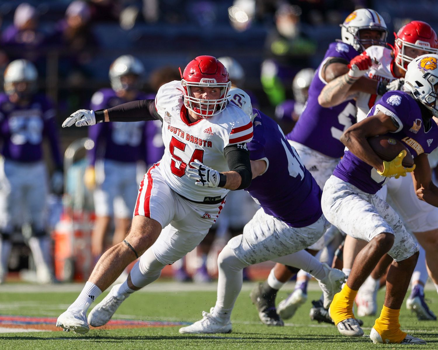 defensive lineman chasing down the running back with the ball