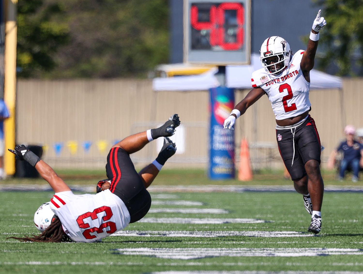 Interception by a linebacker who then falls to the ground as his teammate points in the air indicating the turn over