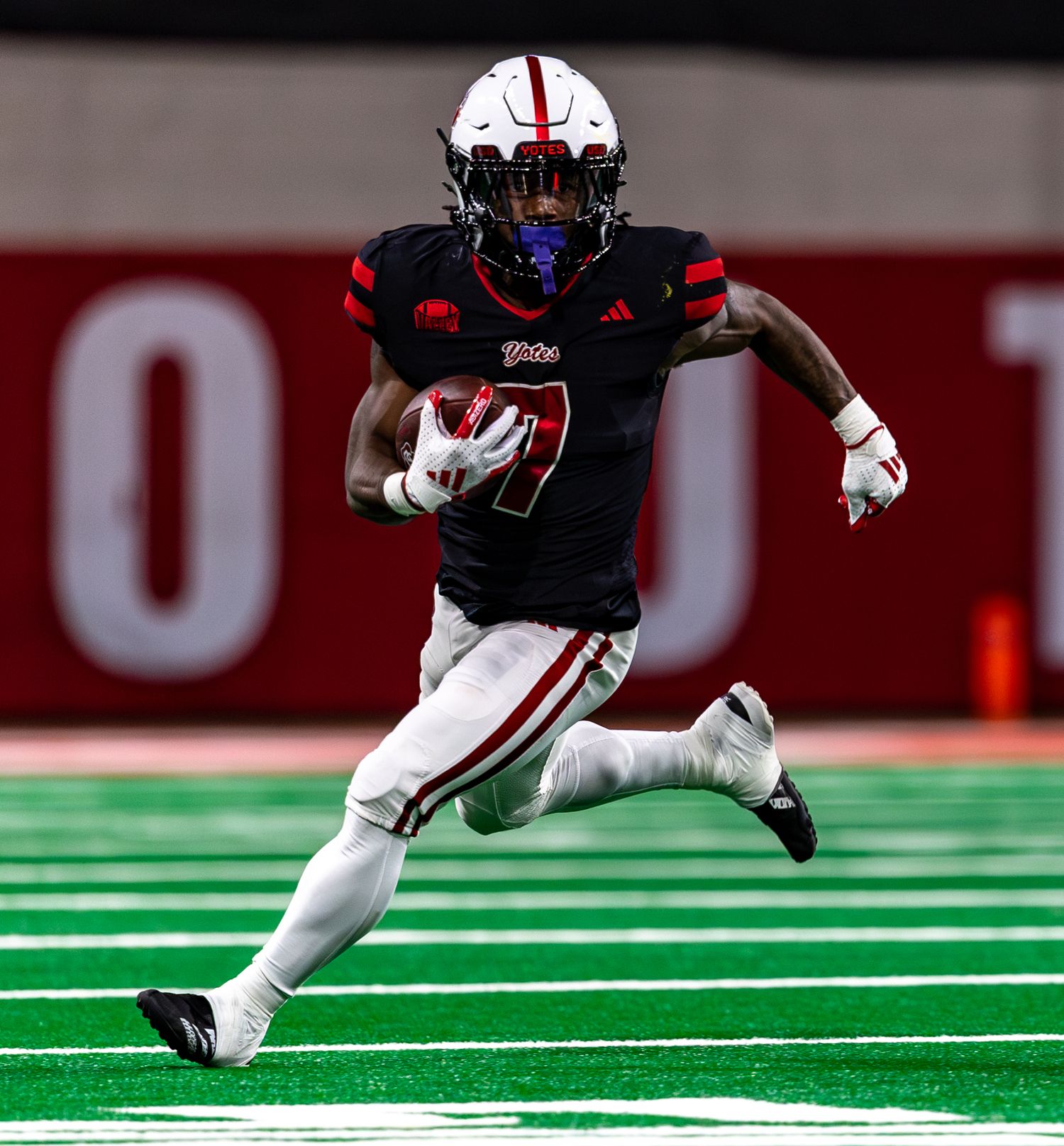 running back running with the ball downfield surveying field ahead for defenders