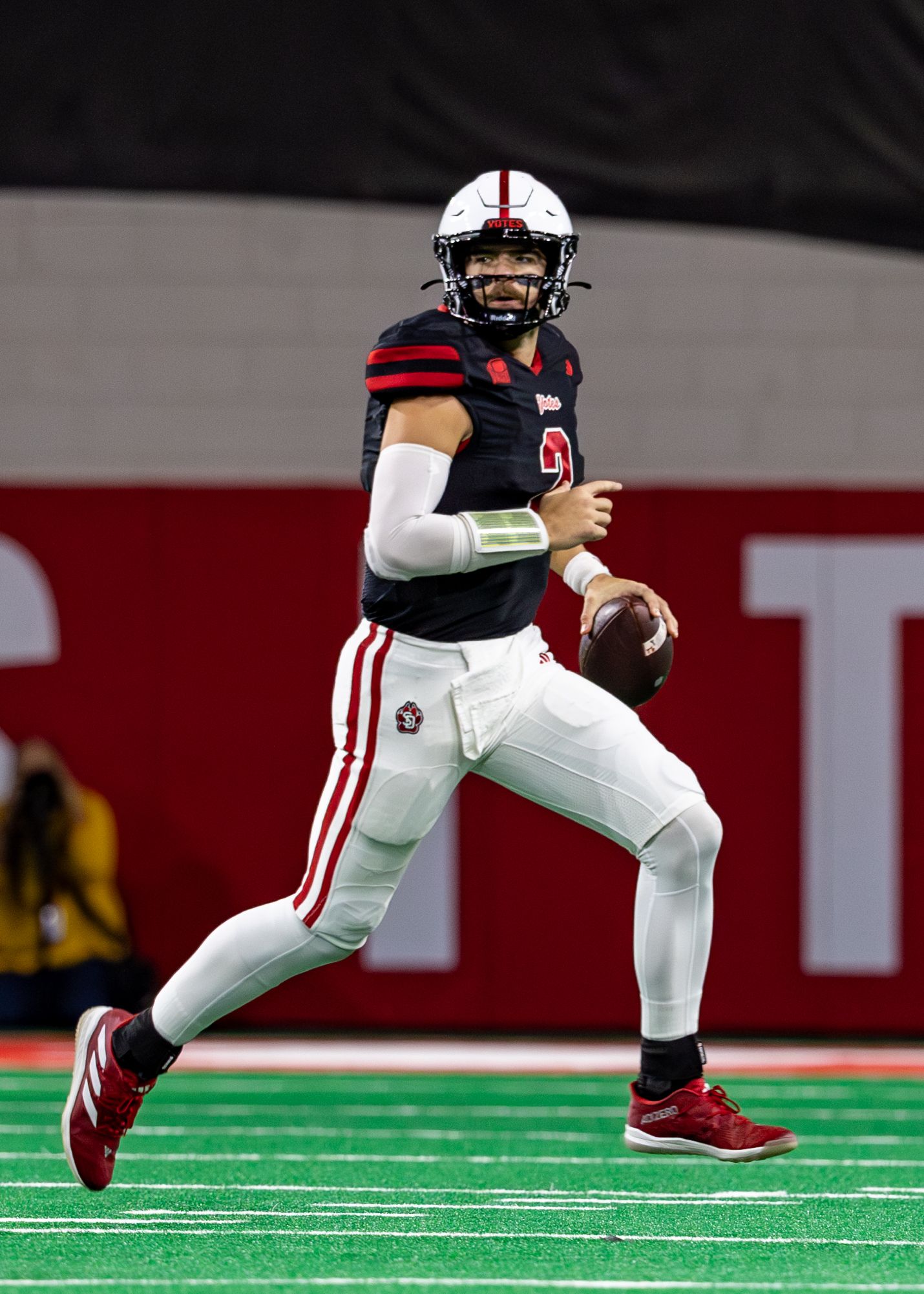 quarterback running with ball looking downfield