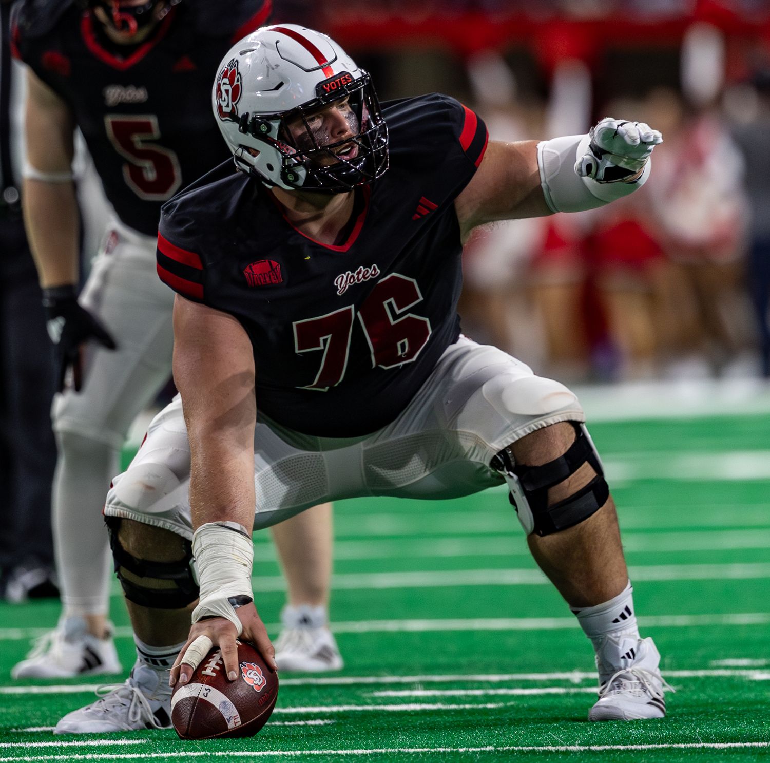 offensive center pointing out protections as he prepares to snap the ball