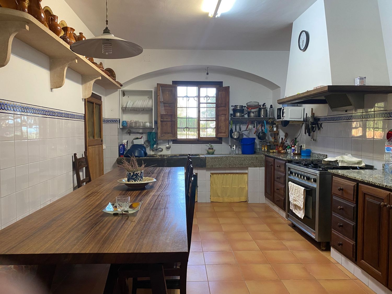 Rustic kitchen with wooden countertops, white tiles, and exposed beams features modern appliances and ample storage space.